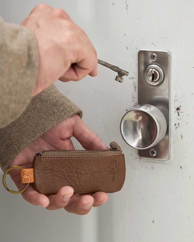 シンプルだけれど目を引くデザインのキーポーチ／キーリングの色：モカグレー