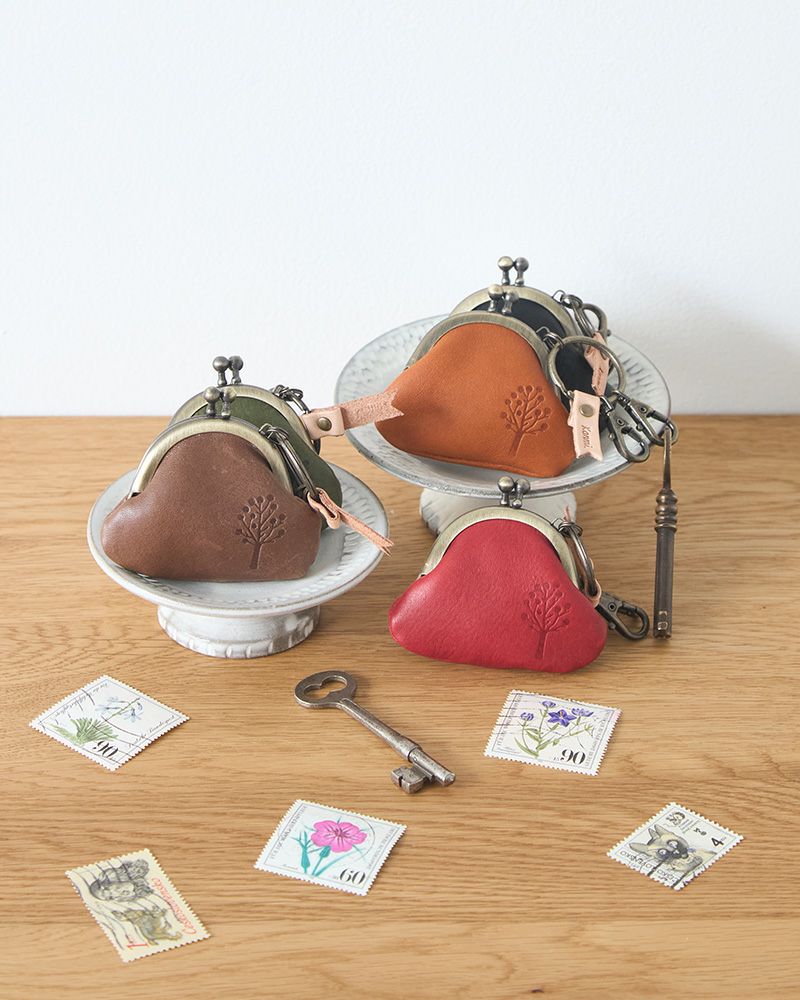 こがま口の色：左手前から モカグレー、グリーン／右手前から レッド、キャメル、クロ