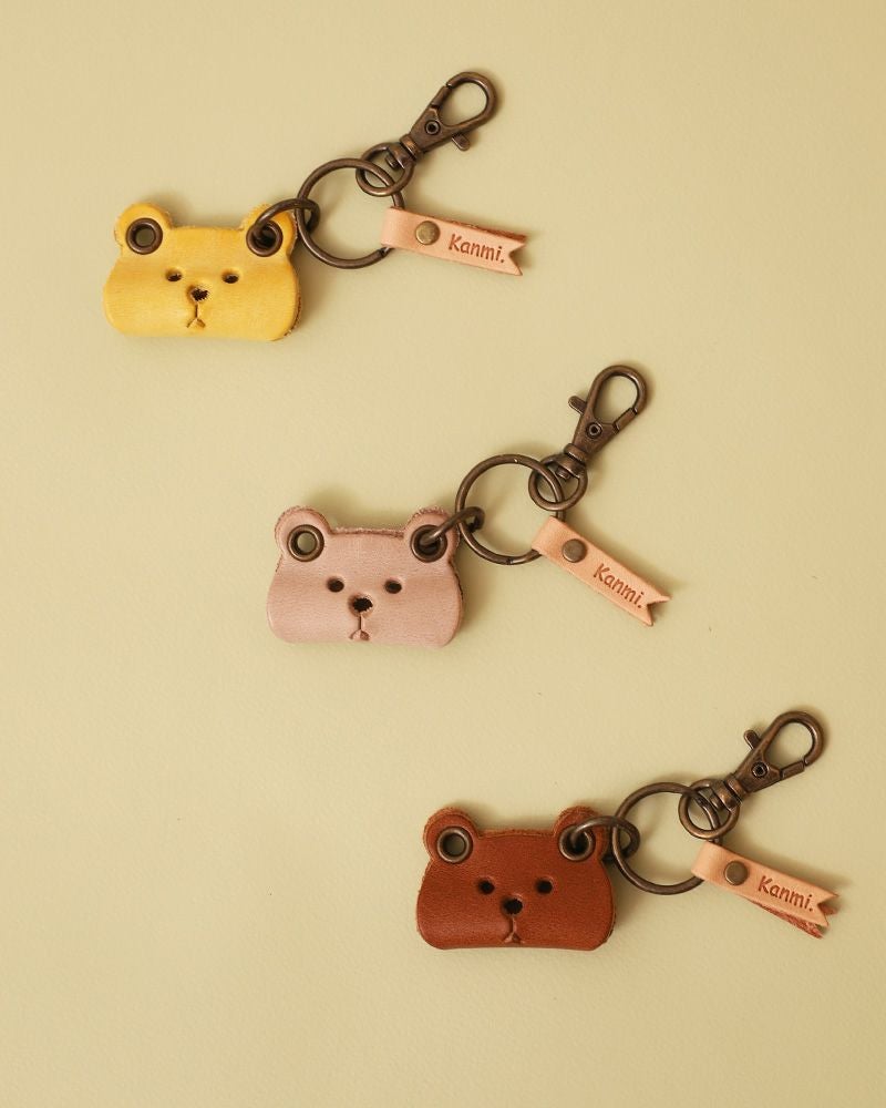 柔らかなニュアンスカラーのクマモチーフが、鍵やポーチに落ち着きを与えるレザーの風合い