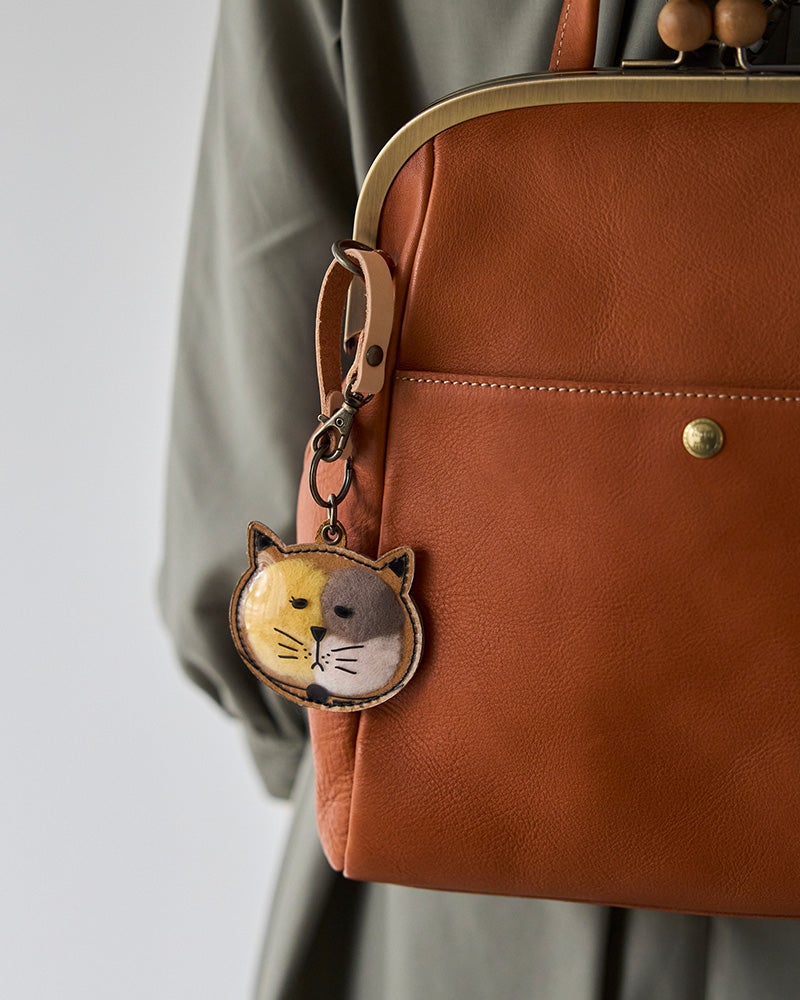 ねこのかたちの中に、大切な存在の毛をそっと。気配を連れて歩くバッグチャーム。（カラー：こまりがお　クロ）