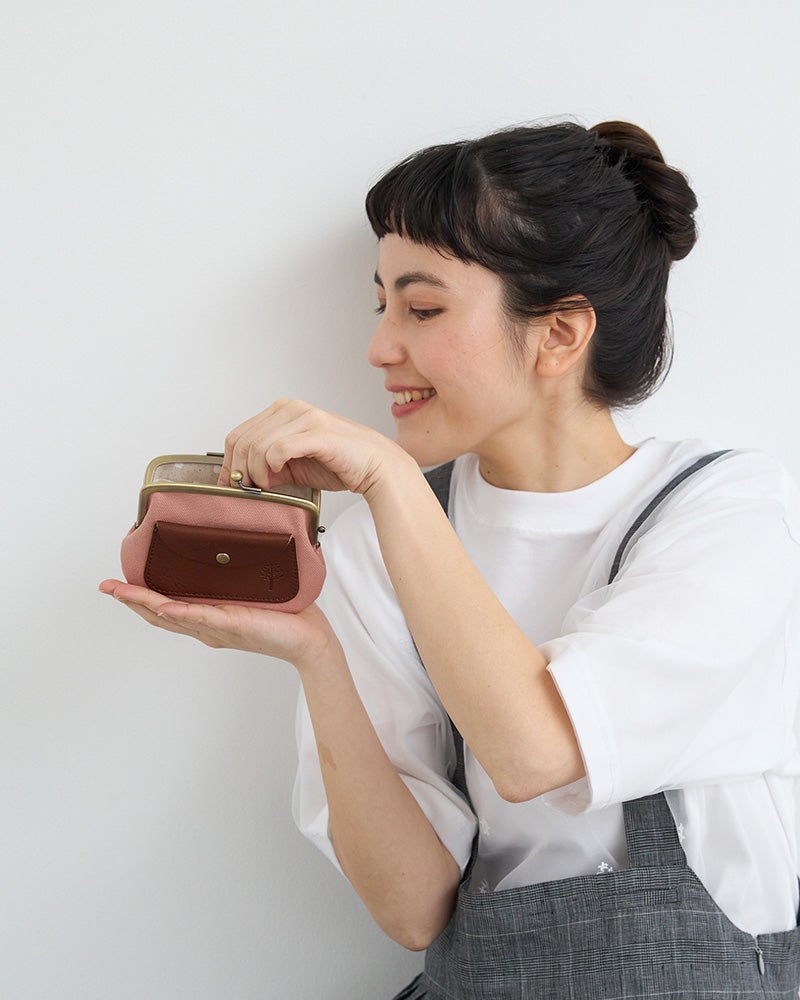 やさしいももいろが、バッグの中でほっと心を和ませる。帆布の軽さと親子がま口の使いやすさを両立した、毎日に寄り添うがま口財布。