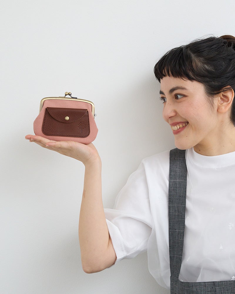 ぱっと目に入るももいろで、バッグの中でも迷わない。がま口×外ポケットで、お会計もスムーズに。