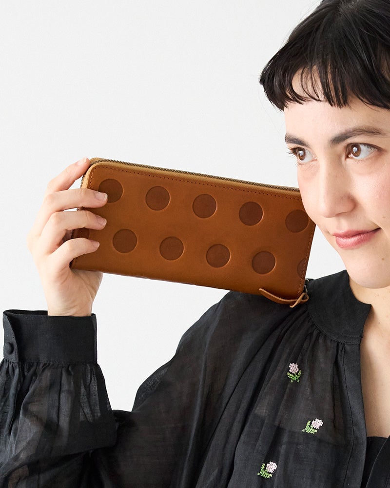 しっとりとしたキャラメル色が魅力のラウンドロングウォレット。使うほど手になじみ、革の風合いが深まる楽しさ。