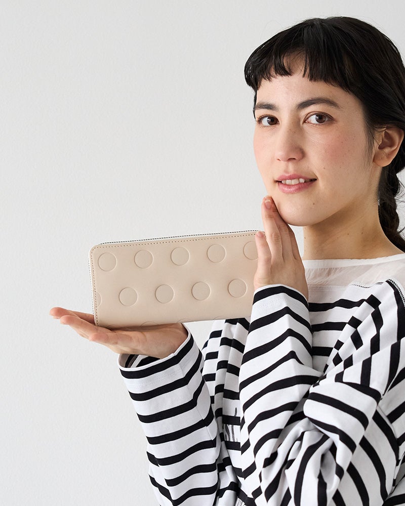 やさしいバニラカラーで、大容量でも軽やかな印象。水玉模様が可愛く、使うたび気持ちがほっとするラウンド長財布。