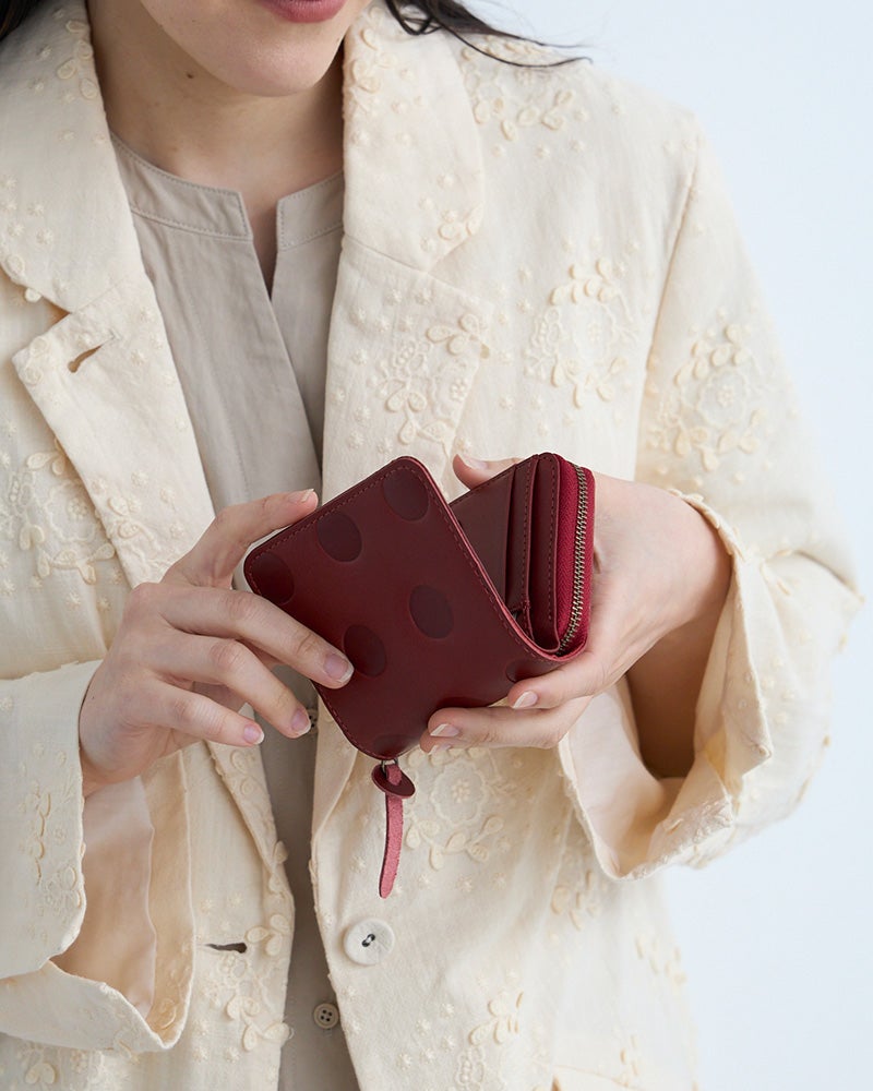 深みのあるチェリーレッドが手元をきれいに見せるラウンドショートウォレット。ポケットサイズでも、お札はまっすぐ入る安心感。