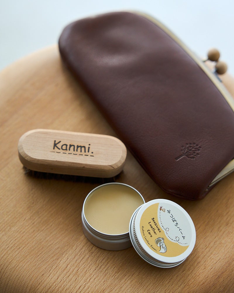 Kanmi.の革に合わせて選んだみつばちバームと、日本製の馬毛ブラシ、やさしい肌触りのクロスをセット。本革バッグや財布のお手入れを気軽に始められます。