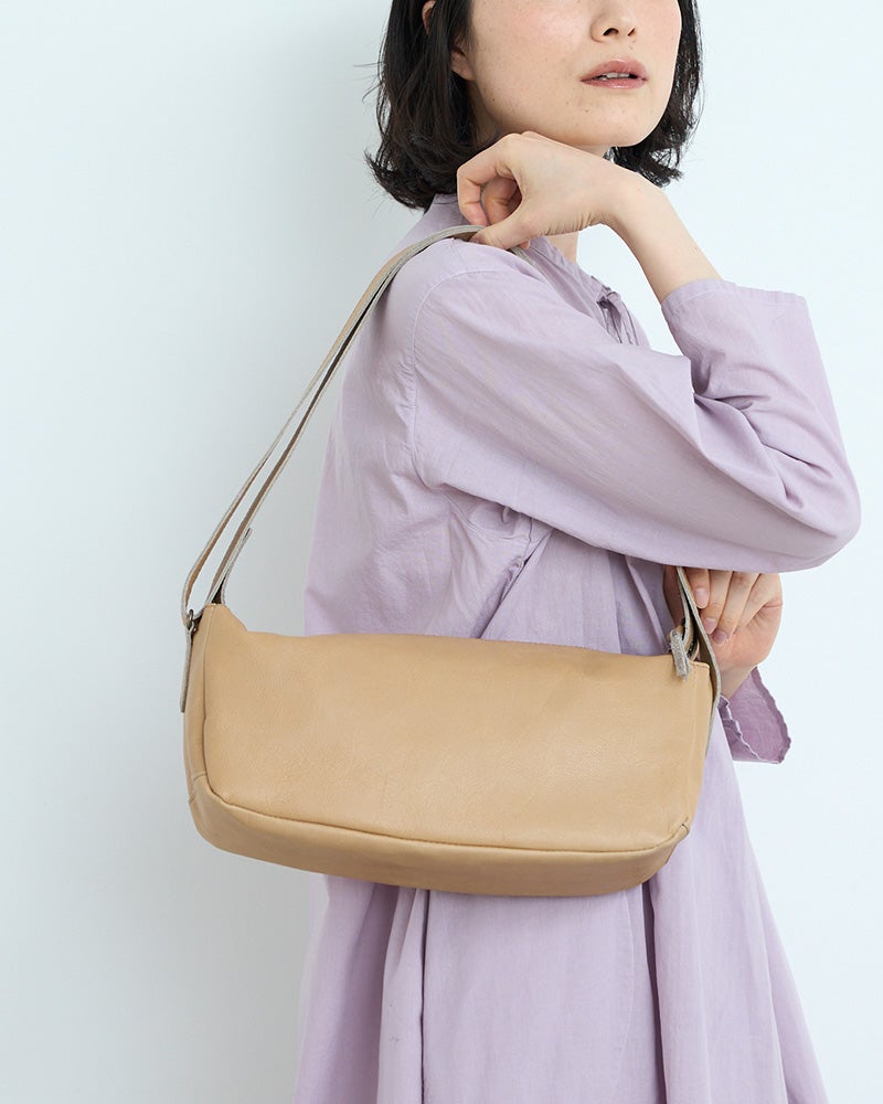 ころんと横長、どこか愛嬌のある佇まい。かわいさを大人っぽく楽しめる、本革ショルダーバッグです。