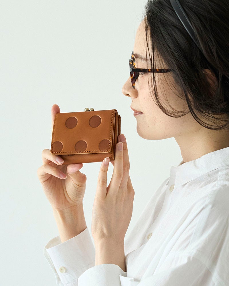 ころんとかわいい水玉模様に、頼れる収納力。小さなバッグにも入れやすく、お札もカードも小銭も整理できる本革の三つ折り財布です。