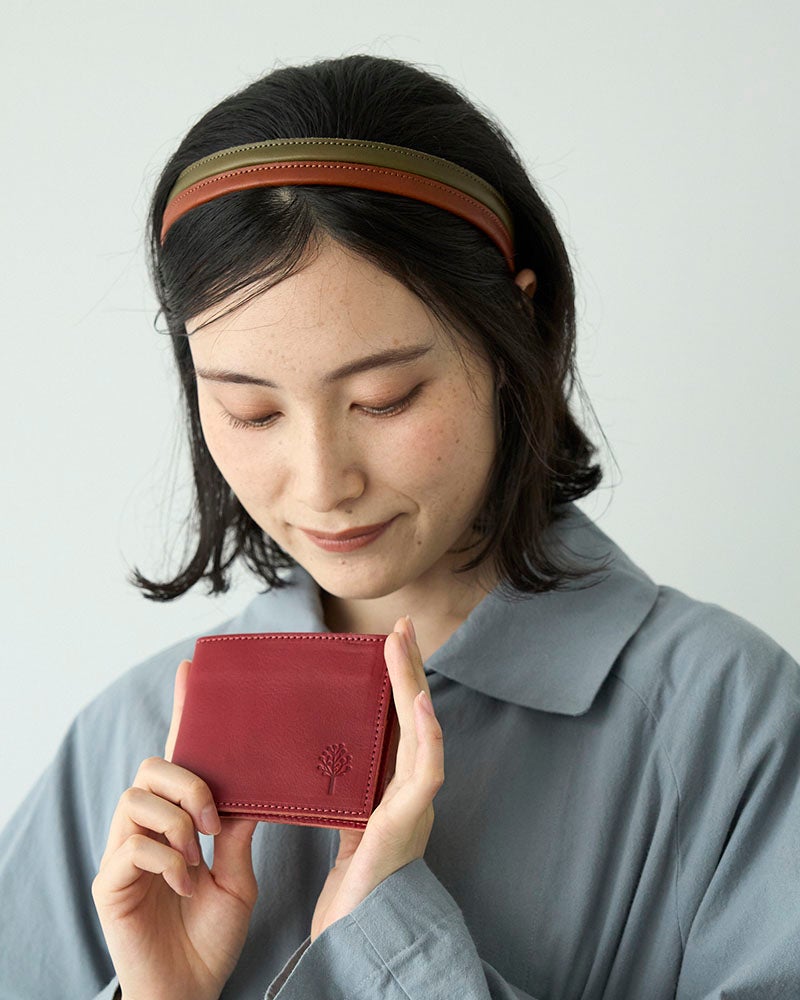 深みのあるレッドが、毎日の手元にさりげない華やかさを。派手すぎず落ち着いた赤だから、大人の女性にも男性にも似合う本革二つ折り財布です。小さなサイズでも存在感があり、バッグの中でも見つけやすいカラーです。