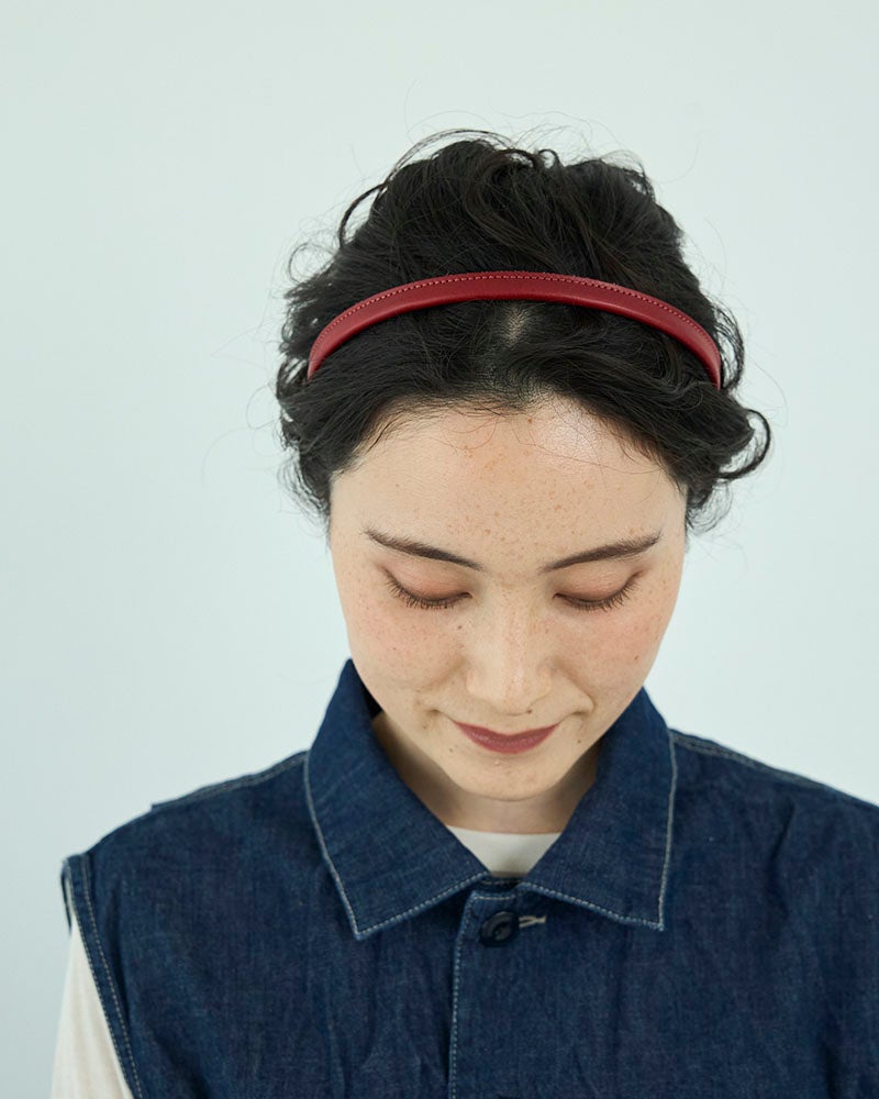 いつもの髪型に、ぱっと華やかなレッドをひとつ。深みのある赤だから大人の装いにも取り入れやすく、シンプルなコーディネートの差し色として楽しめる本革カチューシャです。