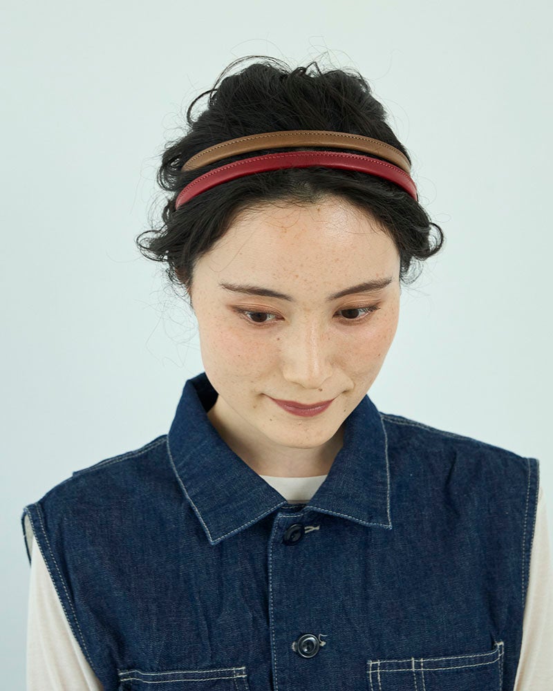 上品なモカグレーと深みのあるレッド。2本重ねても甘くなりすぎず、顔まわりにほどよい華やかさを添えてくれる、大人のレザーヘアアクセサリーです。（カラー/上：モカグレー、下：レッド)